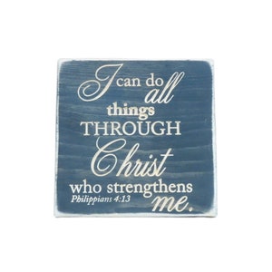 May include: A blue wooden sign with white lettering that reads "I can do all things THROUGH Christ who strengthens me. Philippians 4:13"