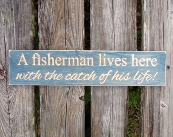 a fisherman lives here with the catch of his life sign, catch of his life, fisherman, fish, fisherman lives here, fishing sign, wood sign