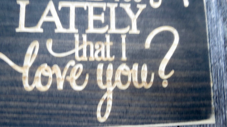 May include: A wooden sign with the text "Have you noticed lately that I love you?" in white lettering on a dark brown background.
