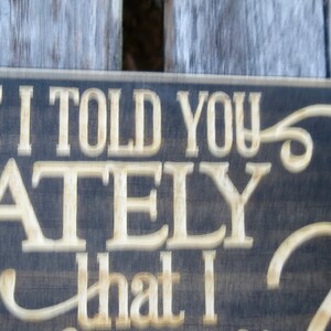 May include: A dark wood sign with white lettering that reads "Have I told you lately that I love you?" The sign has a decorative flourish at the end of the sentence.
