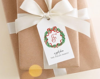 Könnte beinhalten: Zwei Geschenke, verpackt in Kraftpapier und mit weißem Band gebunden. Ein Geschenkanhänger zeigt ein Kranzdesign mit roten Bändern und dem Buchstaben "S". Auf dem Anhänger steht "a gift from THE FIELDS FAMILY".