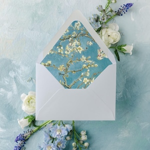 May include: A white envelope with a blue and white floral design on the inside flap. The envelope is shown against a light blue background with white and blue flowers.