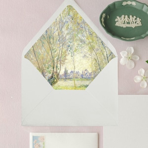 May include: A white envelope with a colorful painting of a landscape with trees and a town in the background. The painting is on the flap of the envelope.