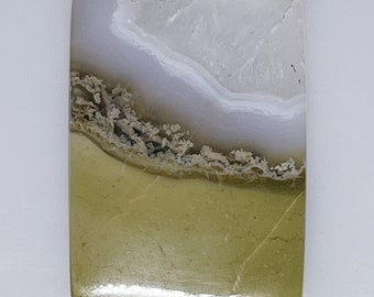 May include: A polished, rectangular, green and white agate cabochon with a layered pattern. The top layer is white with a light purple hue, and the bottom layer is a deep green with a brown, speckled pattern.