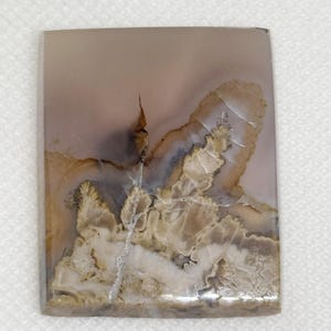 May include: A rectangular slab of agate with a white, brown, and gray pattern. The agate has a smooth, polished surface.