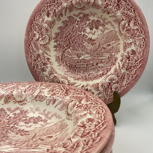 Könnte beinhalten: Ein Stapel von sechs roten und weißen Suppenschalen mit einem Blumenmuster und einer Landschaftsszene. Die Schalen sind aus Keramik und haben einen Vintage-Look.