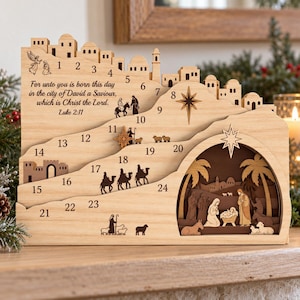 May include: A layered wooden advent calendar featuring a nativity scene, numbered 1 through 24, and the text: For unto you is born this day in the city of David a Saviour, which is Christ the Lord. Luke 2:11. Includes silhouettes of figures.