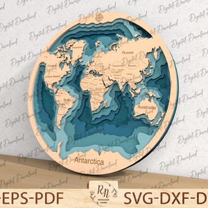 Puede incluir: Un mapa del mundo de madera en capas con un oc&eacute;ano azul y masas de tierra marrones. El mapa es circular y tiene una rosa de los vientos en el centro superior. El texto "Antarctica", "Russia" y "Australia" es visible en el mapa.