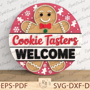 May include: A round wooden sign with a gingerbread man and the words "Cookie Tasters WELCOME". The sign has a red and white color scheme with snowflake and gingerbread man accents. The sign is a festive decoration.