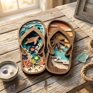 May include: A pair of layered wooden flip-flop wall art pieces. The left piece features an underwater scene with a sea turtle, coral, and fish. The right piece depicts a beach landscape with a palm tree, ocean waves, and a sunset sky.