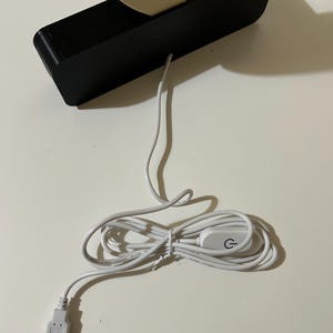 May include: A white USB cable with a power switch and a USB connector. The cable is coiled and the switch has a power symbol.