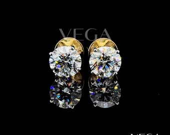 May include: A pair of sparkling diamond stud earrings with gold settings. The round-cut diamonds are the focal point, reflecting light and set against a black background. The earrings are displayed with their reflections.