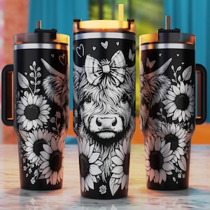 May include: Three black stainless steel tumblers with a white design of a Highland cow with a bow, sunflowers, and other floral elements.