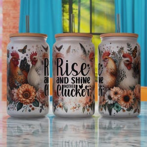 May include: Three white stainless steel tumblers with a wood lid and a straw. The tumblers feature a floral design with chickens and the text "Rise and Shine Mother Cluckers".