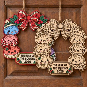 May include: Two hanging wooden wreaths featuring cartoon dumplings with faces, winter hats, and scarves. One wreath is colored red, green, and blue; the other is natural wood. Both feature a bow and a sign reading THE YEAR OF THE SQUISHY 2026.