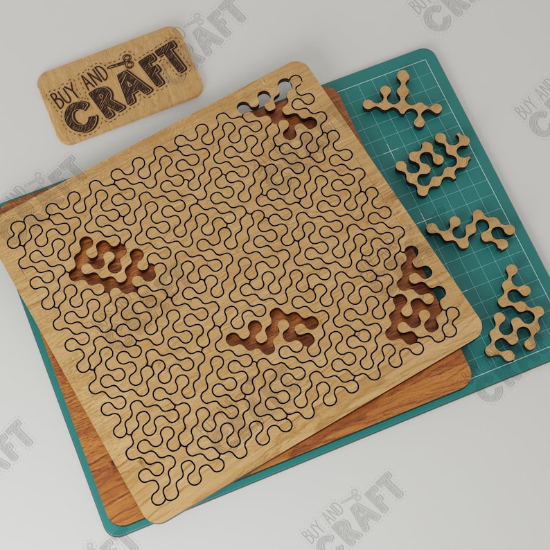 May include: A wooden puzzle with a maze pattern and several separate pieces. The puzzle is made of light brown wood and has a black outline. The pieces are also made of light brown wood and have a black outline. The puzzle is on a green cutting mat. The text "Buy and Craft" is on a small wooden sign.