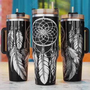 May include: Three black stainless steel tumblers with a white dreamcatcher and feather design. The tumblers have a handle and a straw lid.