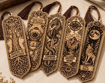 May include: Five rectangular wooden bookmarks with dark brown tassels, each featuring intricate laser-engraved designs: a tree with 'ROOTED IN KNOWLEDGE', a diving helmet with 'DIVE INTO THE UNKNOWN', a dragon and sword with 'CONQUER YOUR FEARS', a mountain landscape with 'WANDER MORE', and a wolf howling at the moon with 'STAY WILD'.