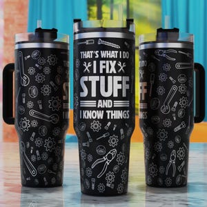 以下が含まれることがあります： 黒いステンレス製のタンブラーに、白い工具のデザインと「That's what I do I fix stuff and I know things」というテキストが書かれています。
