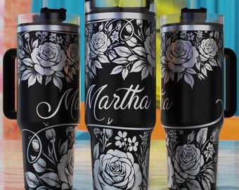 May include: Three black stainless steel tumblers with a white floral design and the name "Martha" on the middle tumbler.