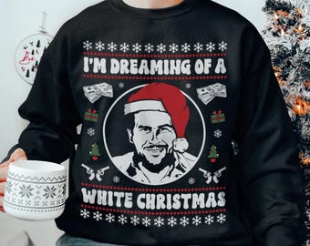 Puede incluir: Suéter navideño negro con un patrón de copo de nieve blanco. Presenta un retrato de un hombre con un gorro de Papá Noel y el texto "I'm Dreaming of a White Christmas".