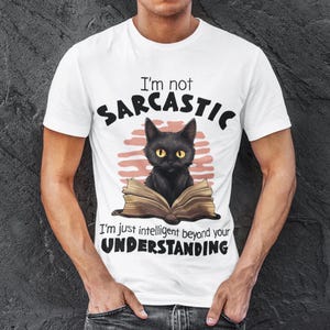 May include: White t-shirt with a black cat reading a book. The text on the shirt reads "I'm not sarcastic, I'm just intelligent beyond your understanding."