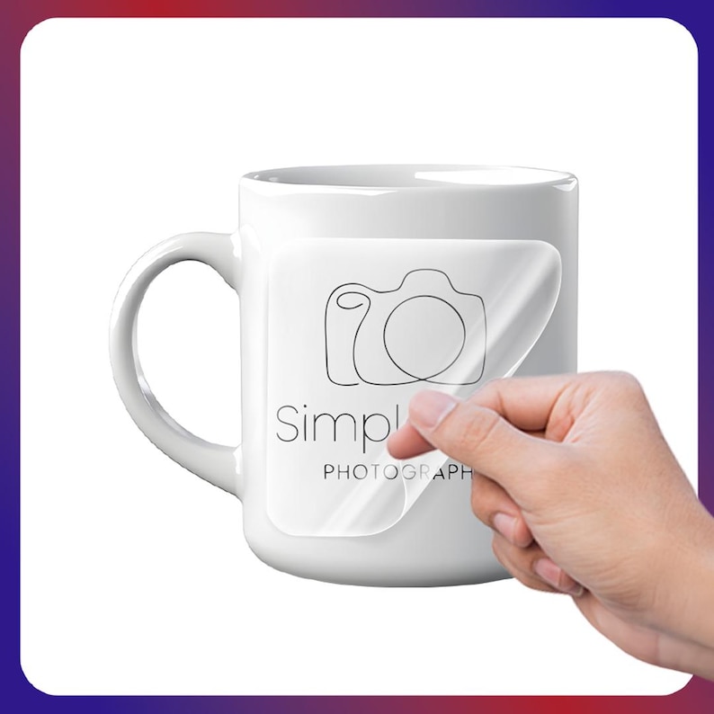 May include: White ceramic mug with a large handle. A clear sticker with a camera outline and the words "Simple PHOTOGRAPH" is being peeled off the mug. The mug is on a white background.