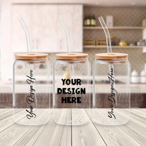 May include: Three clear glass drinking jars with bamboo lids and curved glass straws. The center jar has the text "YOUR DESIGN HERE" in bold black letters. The other two jars have the text "Your Design Here" in a cursive font.