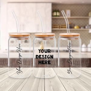 May include: Three clear glass drinking jars with bamboo lids and curved glass straws. The center jar has the text "YOUR DESIGN HERE" in bold black letters. The other two jars have the text "Your Design Here" in a cursive font.