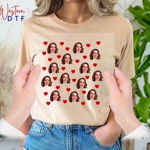 a woman holding a t - shirt with a picture of a woman's face