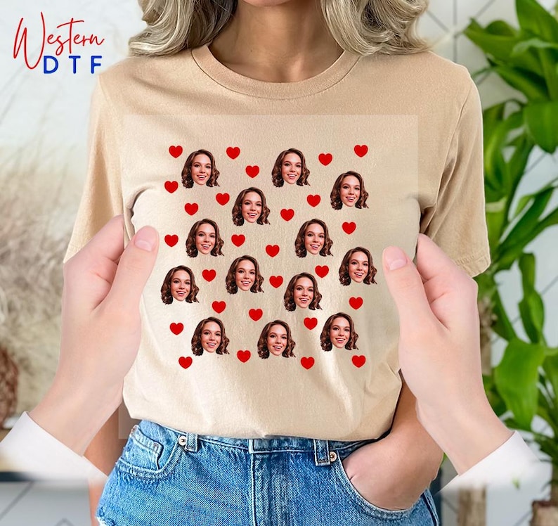 a woman holding a t - shirt with a picture of a woman's face