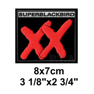 May include: Embroidered patch with the text "SUPERBLACKBIRD" above two overlapping red "X" shapes on a black background. The patch measures 3 1/8" x 2 3/4".