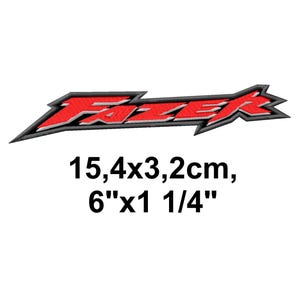 May include: Embroidered patch with the word "FAZER" in red, outlined in black and grey. The patch is 15.4cm long and 3.2cm high. The patch is on a white background.