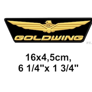 Peut inclure: Écusson brodé noir et or avec le mot "GOLDWING" et un emblème ailé. Dimensions : 16 x 4,5 cm (6 1/4" x 1 3/4").