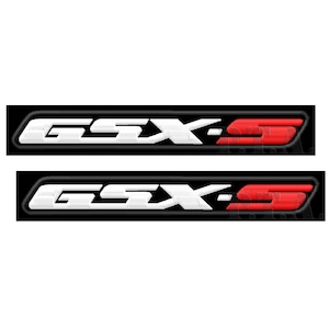 May include: Two embroidered patches featuring the text "GSX-S". The text is white with black outlines, set against a black rectangular background. The "S" is red. The patches are likely for motorcycle apparel.
