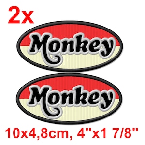 May include: Two embroidered patches with the word "Monkey" in black script with a white outline, set against a red and cream oval background. The patches measure 10cm x 4.8cm.