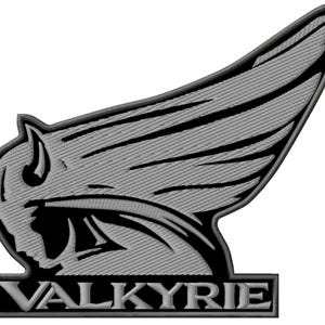 May include: A grey and black Valkyrie emblem, featuring a winged design with a stylized face. The word "VALKYRIE" is displayed in a rectangular border below the winged emblem. The design has a textured, embroidered appearance.
