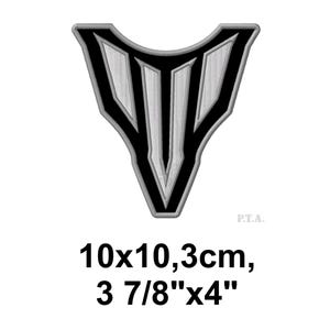 May include: A black and white embroidered patch in a shield shape. The design features vertical stripes within a black outline. The patch measures 3 7/8" x 4" (10 x 10.3 cm).