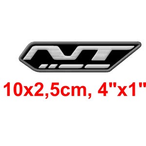 May include: A black and white embroidered patch with the letters "MT" inside a black, rectangular shape. The patch measures 4 inches by 1 inch. The text "10x2,5cm, 4"x1"" is printed in red below the patch.