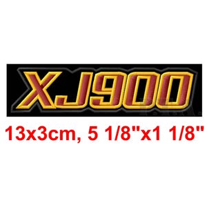 May include: Embroidered patch with the text "XJ900" in red and gold, outlined in gold, on a black background. The patch measures 5 1/8" x 1 1/8" (13x3cm).