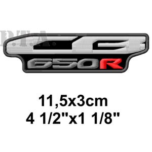 May include: Embroidered patch with the text "C650R" in white and red, outlined in black and gray. The patch measures 4 1/2" x 1 1/8" (11.5 x 3cm).
