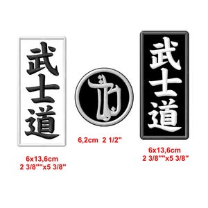 Op de afbeelding: Drie geborduurde patches met de Japanse karakters voor "Bushido" in wit op zwart en zwart op wit. De patches zijn 6,0 cm bij 13,6 cm en 6,2 cm in diameter.