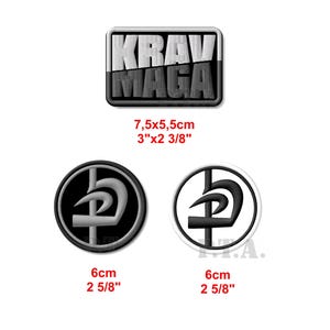 Puede incluir: Tres parches bordados para Krav Maga. El parche más grande es blanco y negro con el texto "KRAV MAGA". Los dos parches más pequeños son circulares y presentan un símbolo negro y gris. Los parches miden 7,5 cm x 5,5 cm y 6 cm de diámetro.