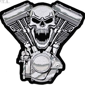 May include: Embroidered patch depicting a skull with an open mouth, set against a motorcycle engine design. The patch is mainly black and white, with detailed stitching and the letters "P.T.A." in the upper left corner.