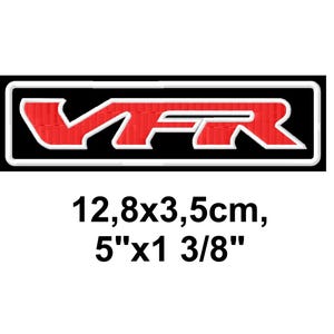 May include: A rectangular patch with the letters "VFR" in red, outlined in white, on a black background. The patch measures 5" x 1 3/8".