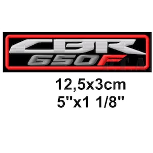 May include: Embroidered patch with the text "CBR 650F" in white and gray, outlined in red, on a black background. The patch measures 5" x 1 1/8" (12.5 x 3 cm).