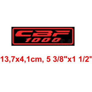 May include: A red and black embroidered patch with the text "CBR 1000". The patch is rectangular, measuring 5 3/8" x 1 1/2". The text is in a bold, stylized font.