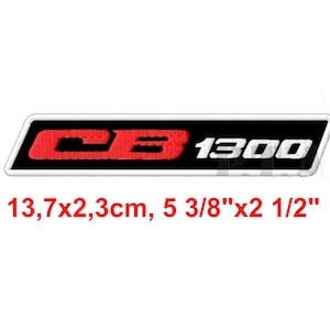 May include: A rectangular emblem with the text "CB 1300". The "CB" is red, and the "1300" is white. The emblem is 5 3/8" long and 2 1/2" wide, with a black background and a white border.