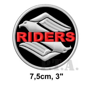 Può includere: Una toppa circolare con sfondo nero e disegno di aquila bianca con testo rosso "RIDERS". La toppa misura circa 7,5 cm di diametro.