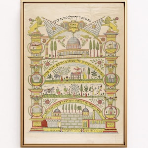 May include: A framed, colorful print with Hebrew text and illustrations. The artwork features architectural elements, flags, and figures, with a gold-colored frame. The print is likely a religious or historical depiction.